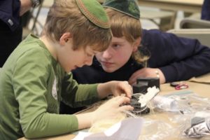 Two Kesher Tefillin participants working on their Tefillin