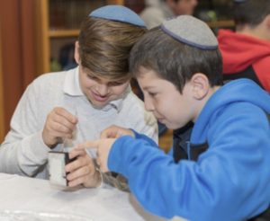 Two students working on their Tefillin during the Kesher Tefillin program